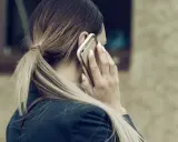 Kobieta rozmawia przez telefon, martwiąc się, czy pracodawca może odmówić urlopu na żądanie.